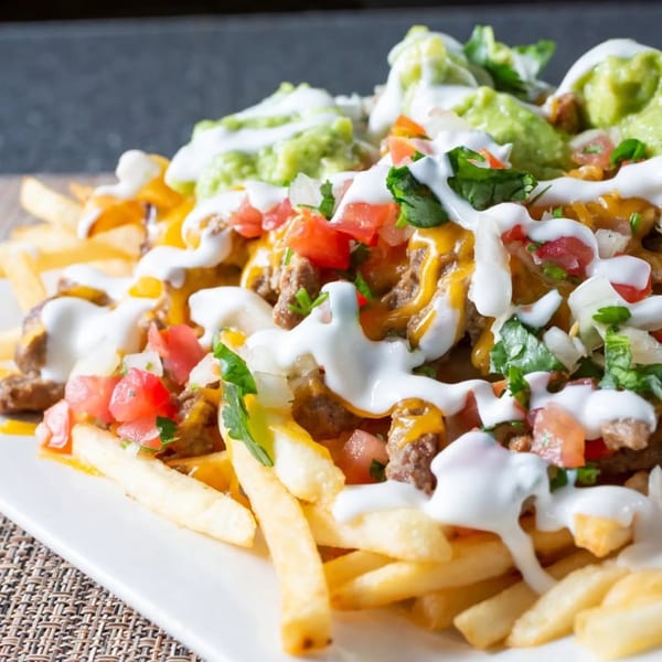 Loaded fries with cheese, ground beef, diced tomatoes, guacamole, and sour cream.